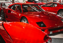 Varios tipos de Ferraris rojos están estacionados en una exposición de coches.
