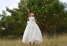 En la imagen se muestra una niña vestida con su vestido de primera comunión divirtiendose.