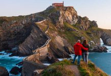 En la imagen se muestra una pareja, disfrutando de su escápada romántica en el País vasco en frente de la isla de San Juan de Gaztelugatxe.